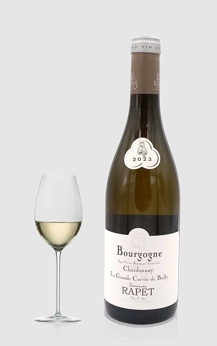 En elegant flaske Domaine Rapet Père et Fils Bourgogne Blanc 2023 hvidvin fra Bourgogne ved siden af et vinglas i et moderne køkken