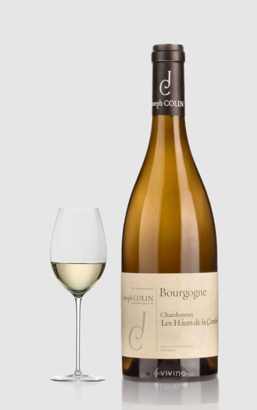 En eksklusiv flaske Joseph Colin Bourgogne Blanc Les Hauts de la Combe 2020 hvidvin fra Chassagne Montrachet og Puligny Montrachet ved siden af et glas i et moderne køkken