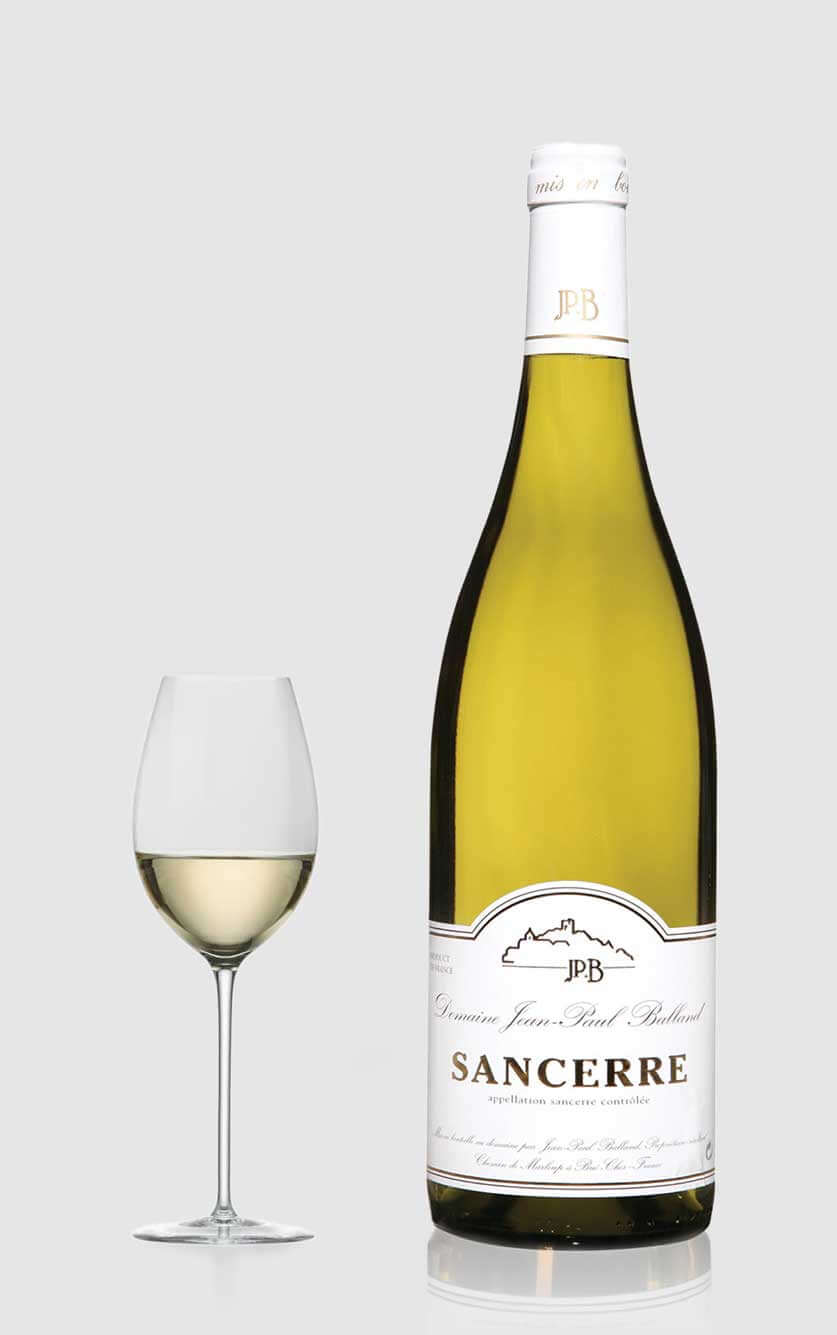En klassisk flaske Domaine Jean Paul Balland Sancerre Blanc 2023 Sauvignon Blanc hvidvin fra Loire ved siden af et glas hvidvin i et moderne køkken