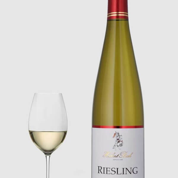 En flot flaske Riesling Alsace hvidvin fra Hubert Beck serveret ved siden af et glas hvidvin på et elegant bord