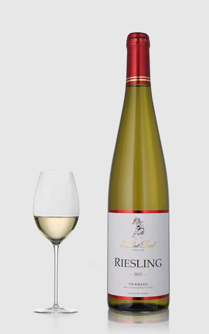 En flot flaske Riesling Alsace hvidvin fra Hubert Beck serveret ved siden af et glas hvidvin på et elegant bord