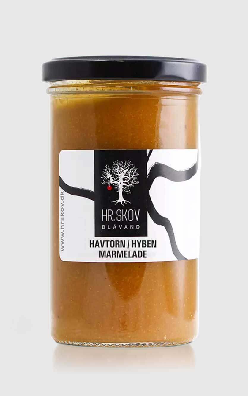 Et glas Hr.Skov havtorn og hyben marmelade med den smukke orange-røde farve serveret ved siden af luftstegte pandekager