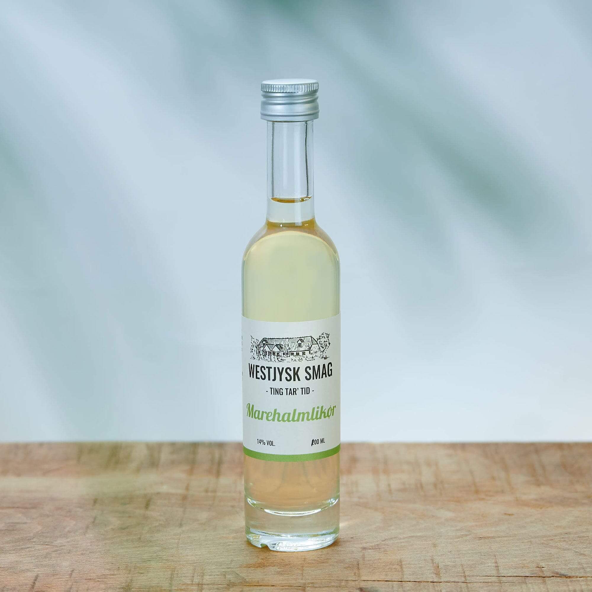 Lille flaske med gylden marehalm likør fra Westjysk Smag stående klar til servering.