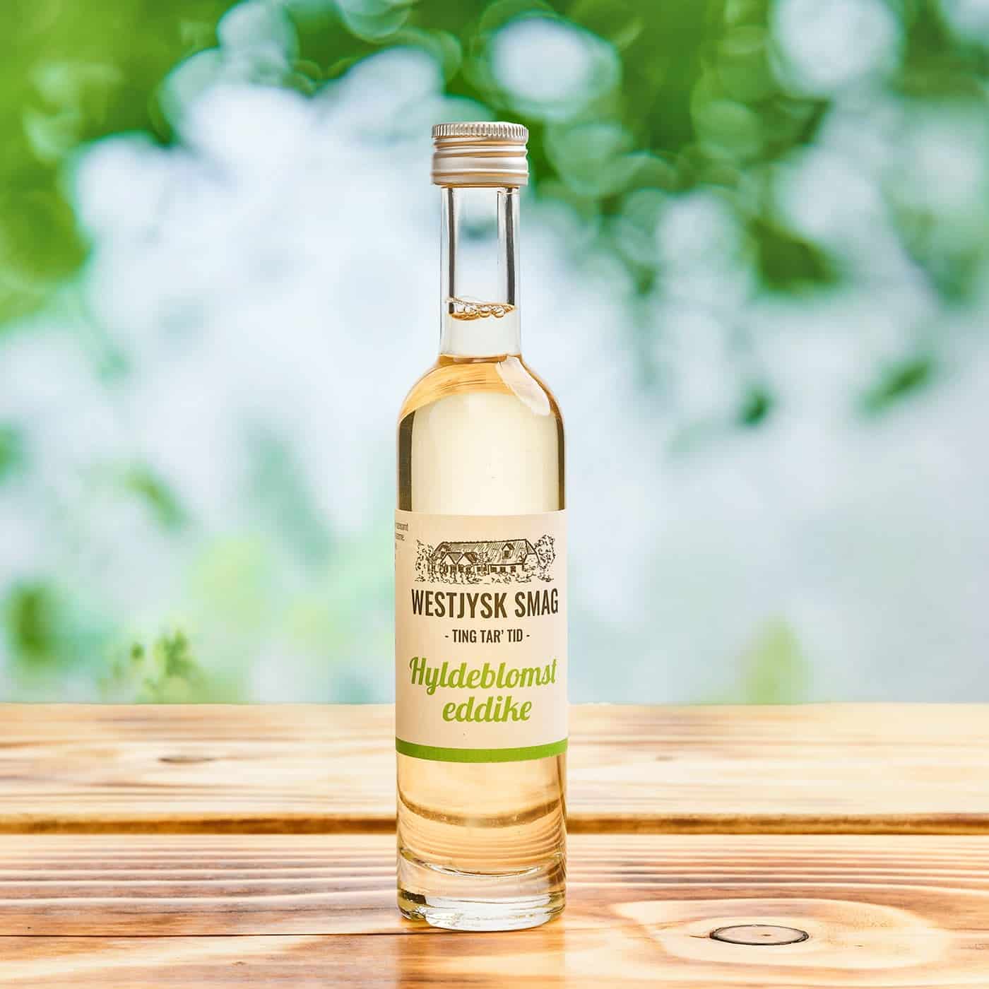 Flaske med hyldeblomsteddike 100 ml klar til brug i dressinger, grøntsager og sommerretter.