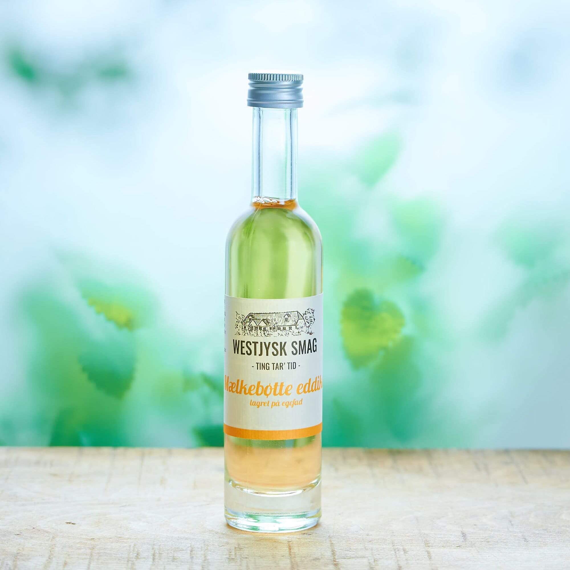 Flaske med mælkebøtte eddike lagret på fad 100 ml klar til brug i dressinger, grøntsager og gourmetretter.