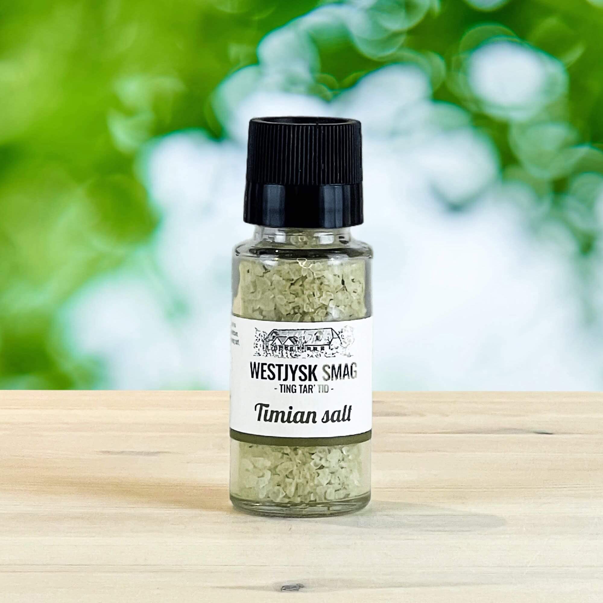 Glas med timian salt blandet med tørrede urter.