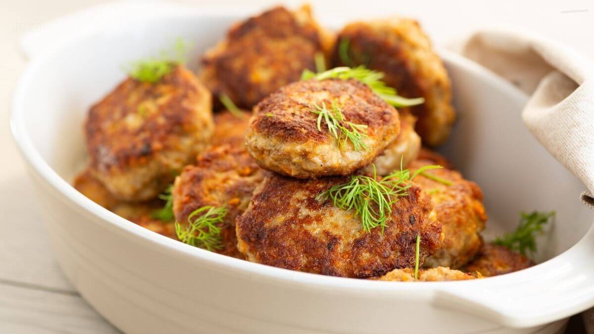 Lakse frikadeller i airfryer serveret i et hvidt ovnfast fad på bordet som nem aftensmad med fisk
