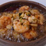 Gambas al ajillo dans un plat chaud avec ail, huile d'olive et herbes
