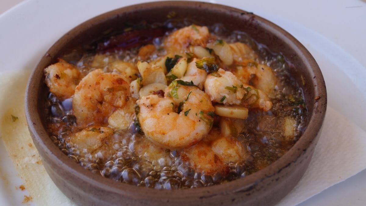 Garlic shrimp gambas al ajillo in a warm dish with garlic, oil and herbs