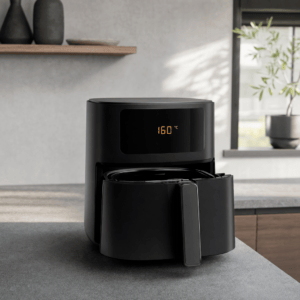 En mat sort airfryer forvarmes til 160 grader