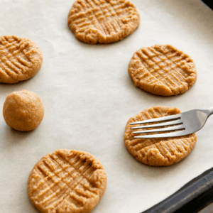 Rå peanutbutter-cookies formes flade med ternmønster