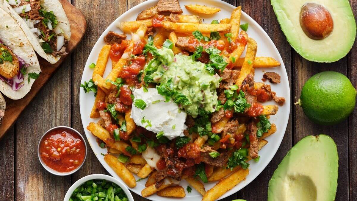 Mexicansk pommes frites toppet med grillet oksekød og guacamole