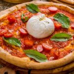 Pizza med frisk cremet burrata, basilikum og kirsebærtomater