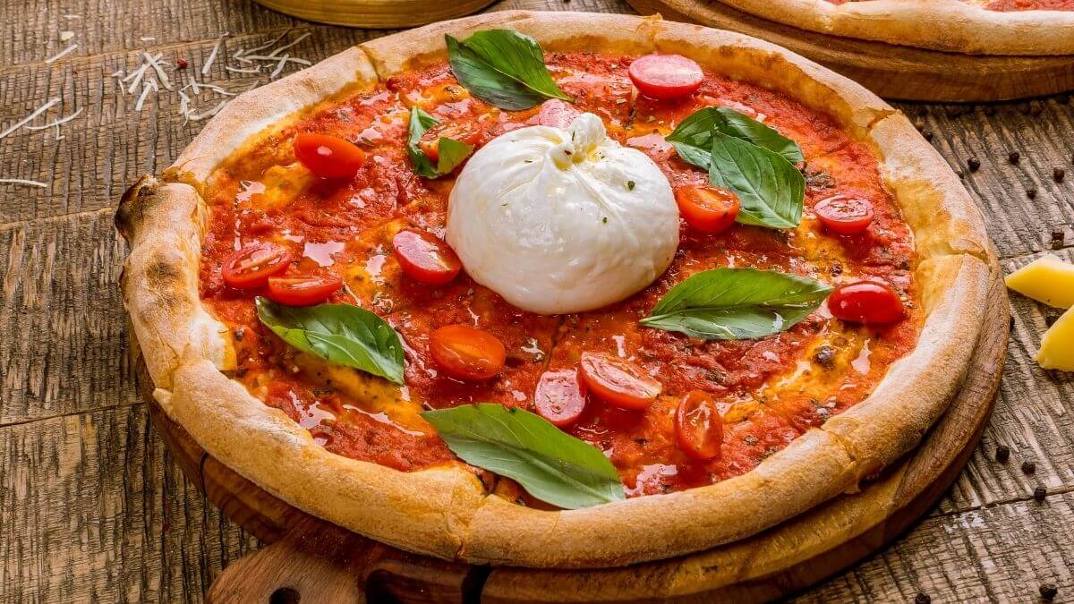 Pizza med frisk cremet burrata, basilikum og kirsebærtomater