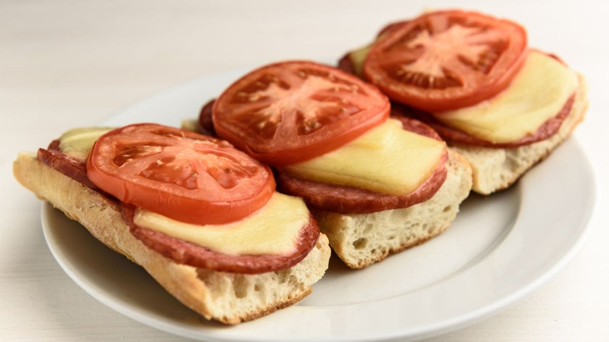 Åben toast med ost, skinke, lidt sennep og tomat skiver.