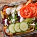 pommes frites toppet med shawarma, smeltet goudaost, salat og hvidløgsdressing.