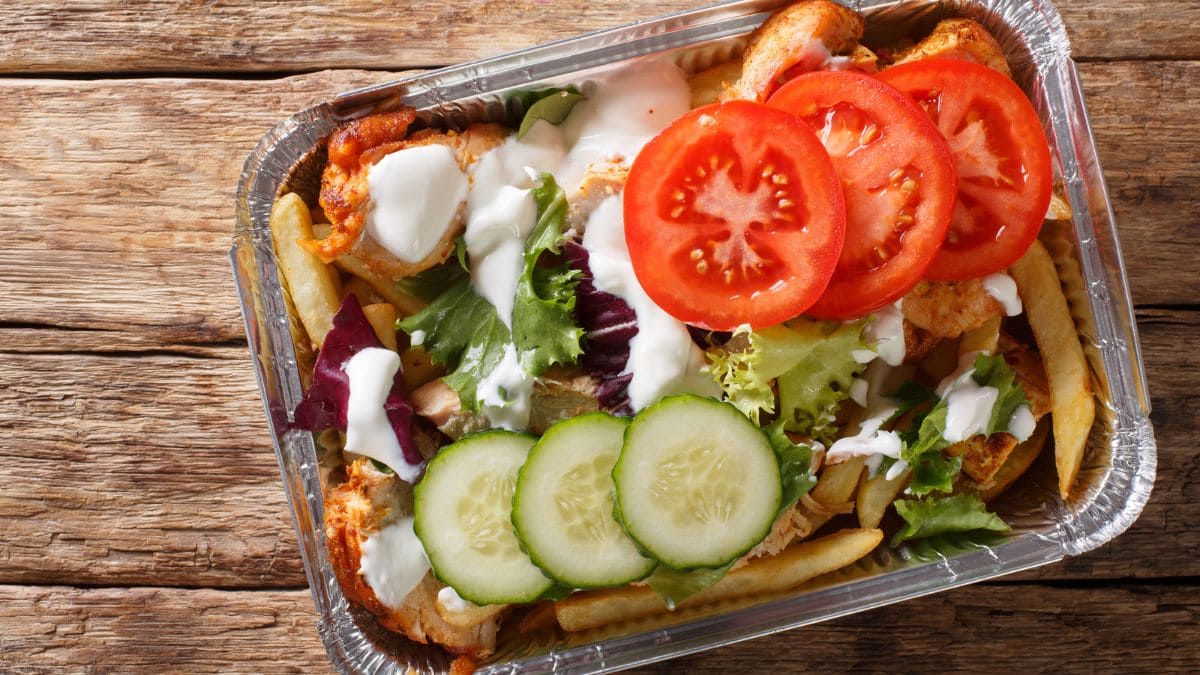 pommes frites toppet med shawarma, smeltet goudaost, salat og hvidløgsdressing.