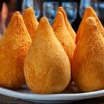 Coxinha er en brasiliansk streetfood, som består af strimlet kyllingekød, dækket af dej, støbt til en form, der ligner en tåre, og stegt