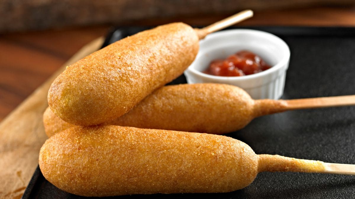 En populær amerikansk snack bestående af en pølser på individuelle spyd, der dyppes i en tyk maismelsdej og bages