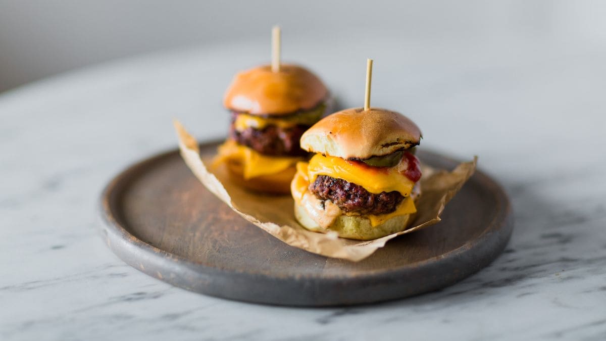 Små, snaskede cheese burgere med ost og oksekød i bløde brioche boller