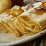 Nalysnyky, panquecas ucranianas tradicionais e finas, enroladas com recheio de queijo e assadas