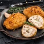 kyllingefilet stødt og rullet rundt om koldt smør, derefter belagt med æg og brødkrummer og bagt