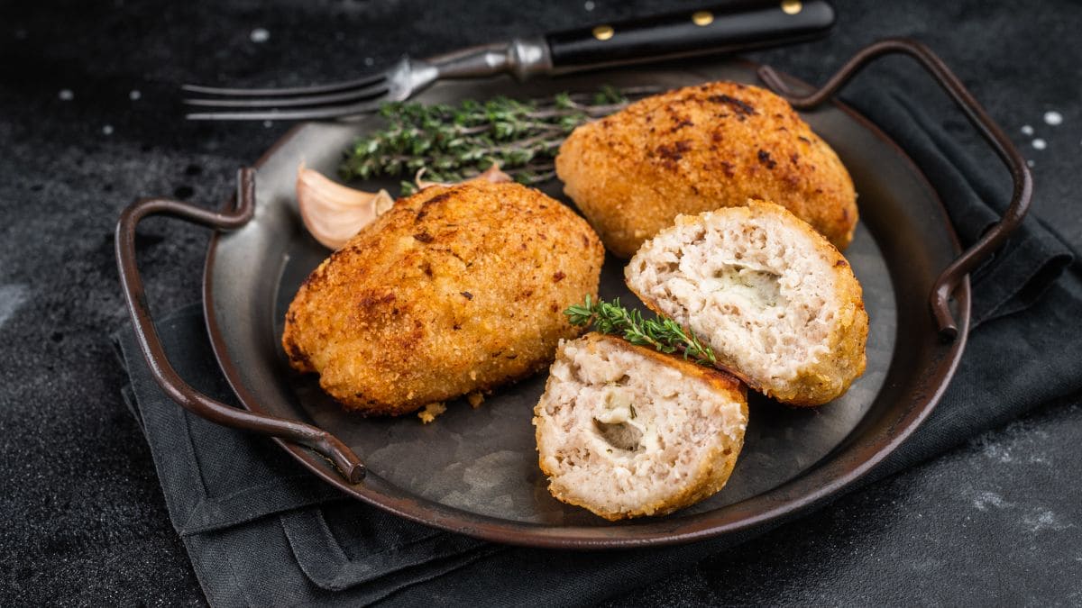 kyllingefilet stødt og rullet rundt om koldt smør, derefter belagt med æg og brødkrummer og bagt