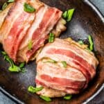 Kyllingbryst gnidd med pepper og omgitt av hele, lange stykker bacon