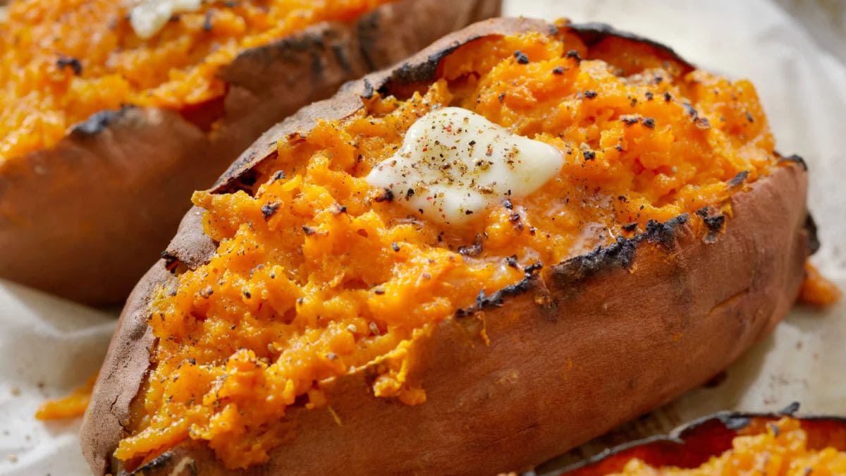 Hel bagt sød kartoffel med creme fraiche, ost, bacon, og hvidløgssmør