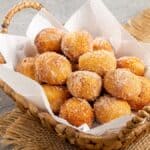 Palline di impasto fritte vengono passate in un mix di zucchero e cannella.