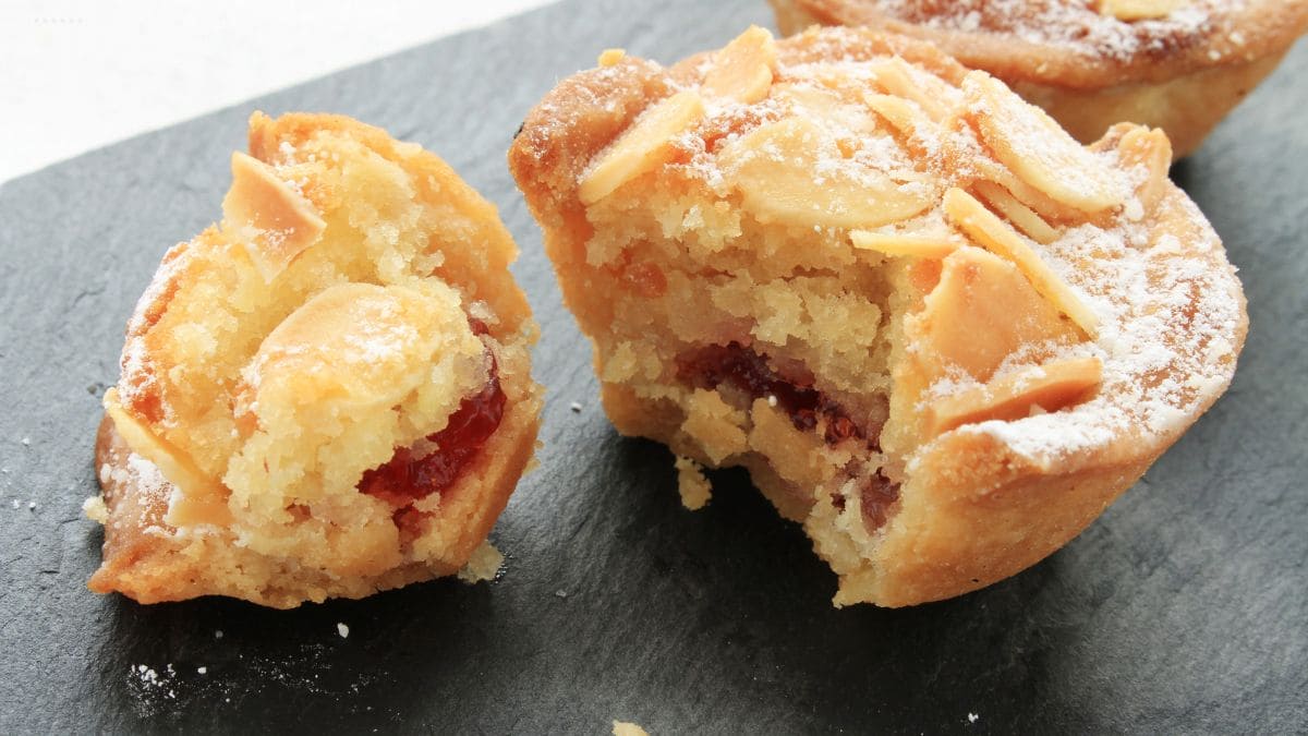 En sprød mørdejsbund muffin smurt med hindbærsyltetøj, fyldt med mandelmasse