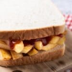 Fries som er tykke, lidt bløde indeni og drysset i salt og lidt eddike, lagt inde i et hvidt brød med smør og ketchup